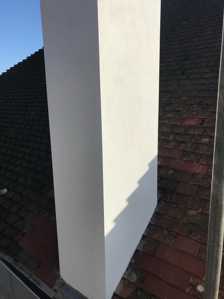 Freshly rendered party wall corner between two roof slopes
